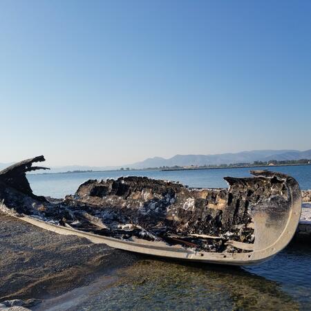 A broken small boat left ashore.