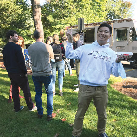 Harvard student Jonathan Zhang poses in front of the waffle truck