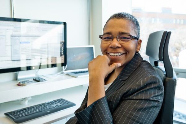Latanya Sweeney sitting at her computer, smiling