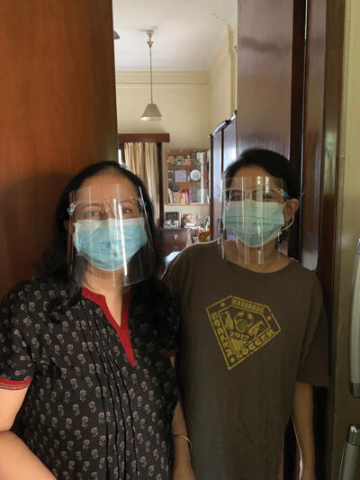 Roshni Chakaborty and colleague standing in the doorway wearing face masks and shields