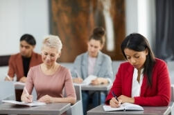 A group of adults taking notes in a class