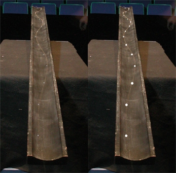 Two views of a scantling, with time lapse images of ball bearings rolling in an accelerating sinusoidal path. The light and heavy bearings trace the same path.