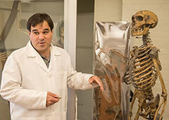 Terence D. Capellini standing next to a human skeleton