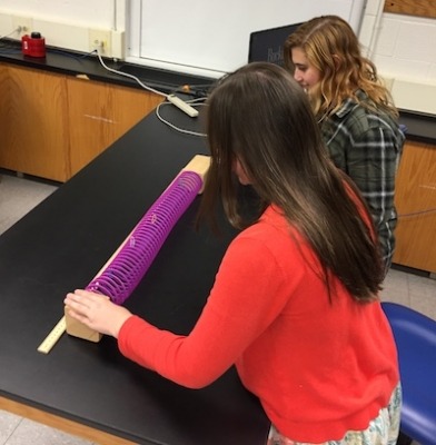 Student working with slinky to learn Hubble law