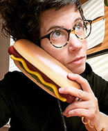 Photo of a woman holding a hot dog shaped phone.