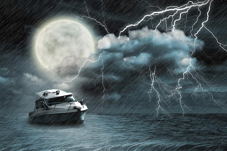 small yacht in lightning storm on the ocean under a large full moon