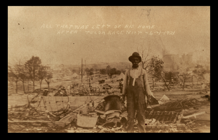 Black man stands in front of his destroyed home in Tulsa