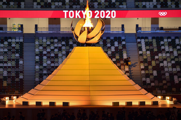 Tokyo 2020 Olympic flame against a background of an empty stadium