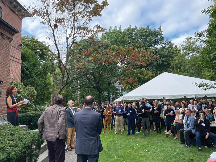 Scholars Program director Erin Goodman welcomes local research center affiliates at an outdoor networking event on the green at 61 Kirkland Street