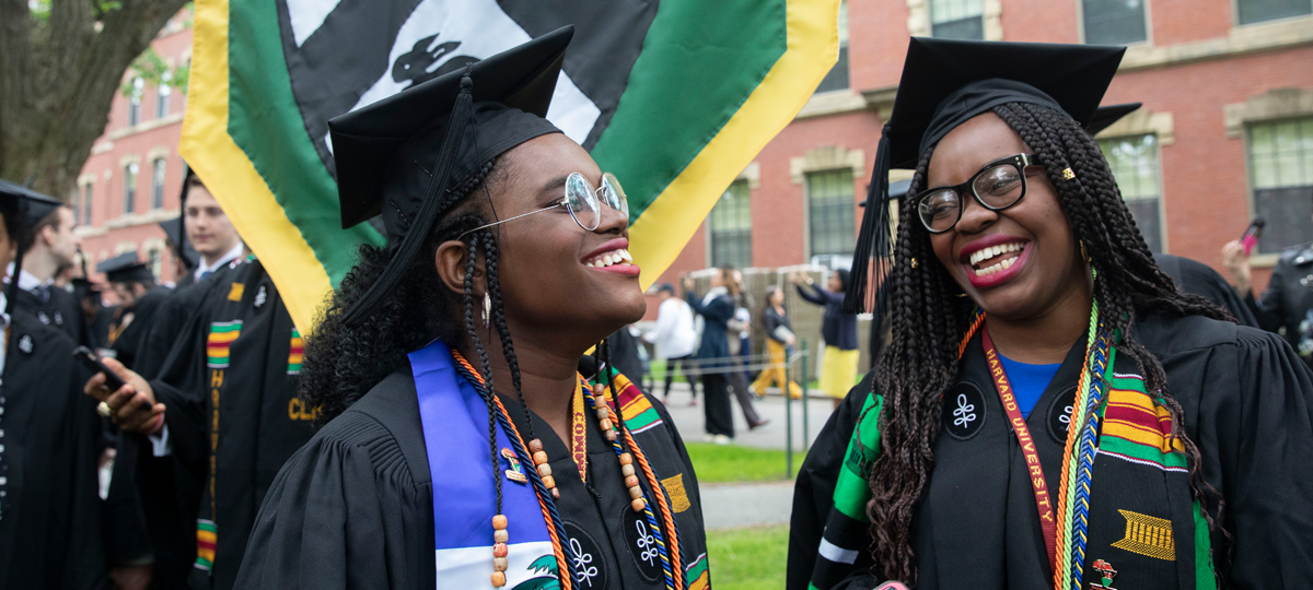 Two Leverett House students smile during Commencement