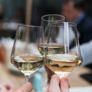 three glasses of white wine touching in "cheers"