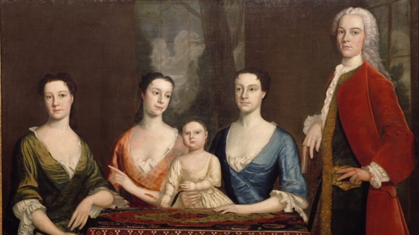 Group portrait of three women, a child, and a man standing on the right.