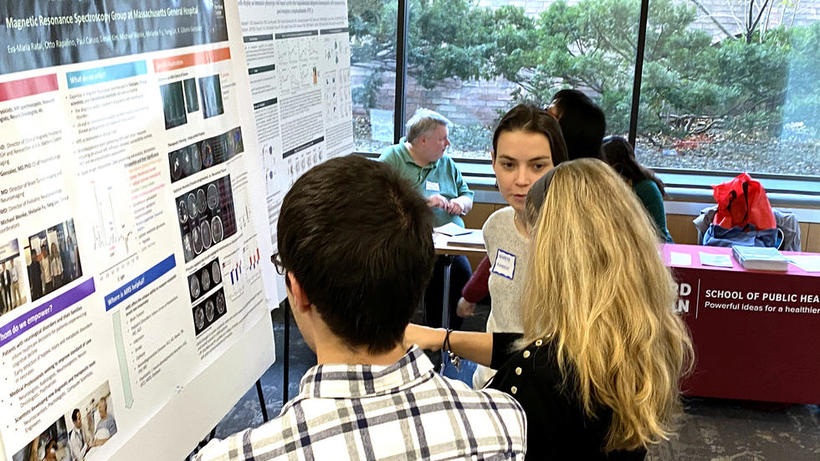 People stand in front of lab poster at HUROS 2019 fair