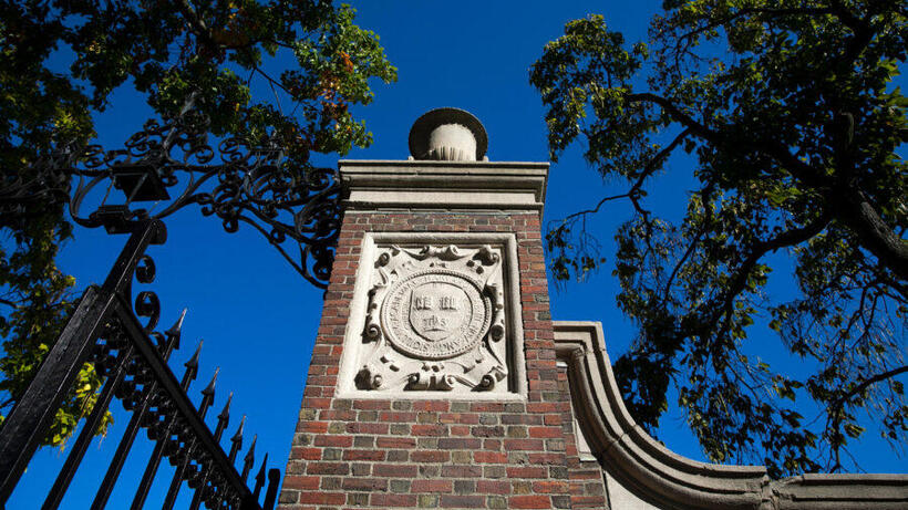 A veritas shield decorates a gate that encircles Harvard Yard.