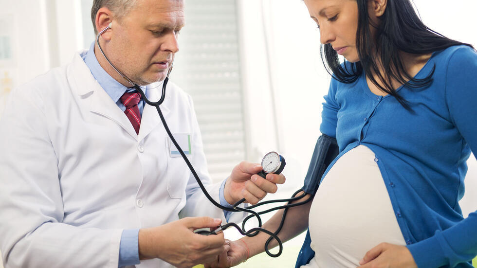 Pregnant woman getting blood pressure checked