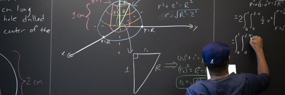 Person working on a math problem at a chalkboard.