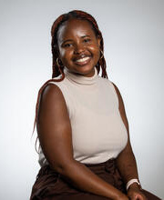 Ananda Birungi, against an off white background, smiling