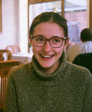 A woman with glasses smiling for the camera