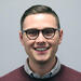 headshot of Resident Tutor, Grant Rigney facing the camera wearing glasses and a Crimson sweater.